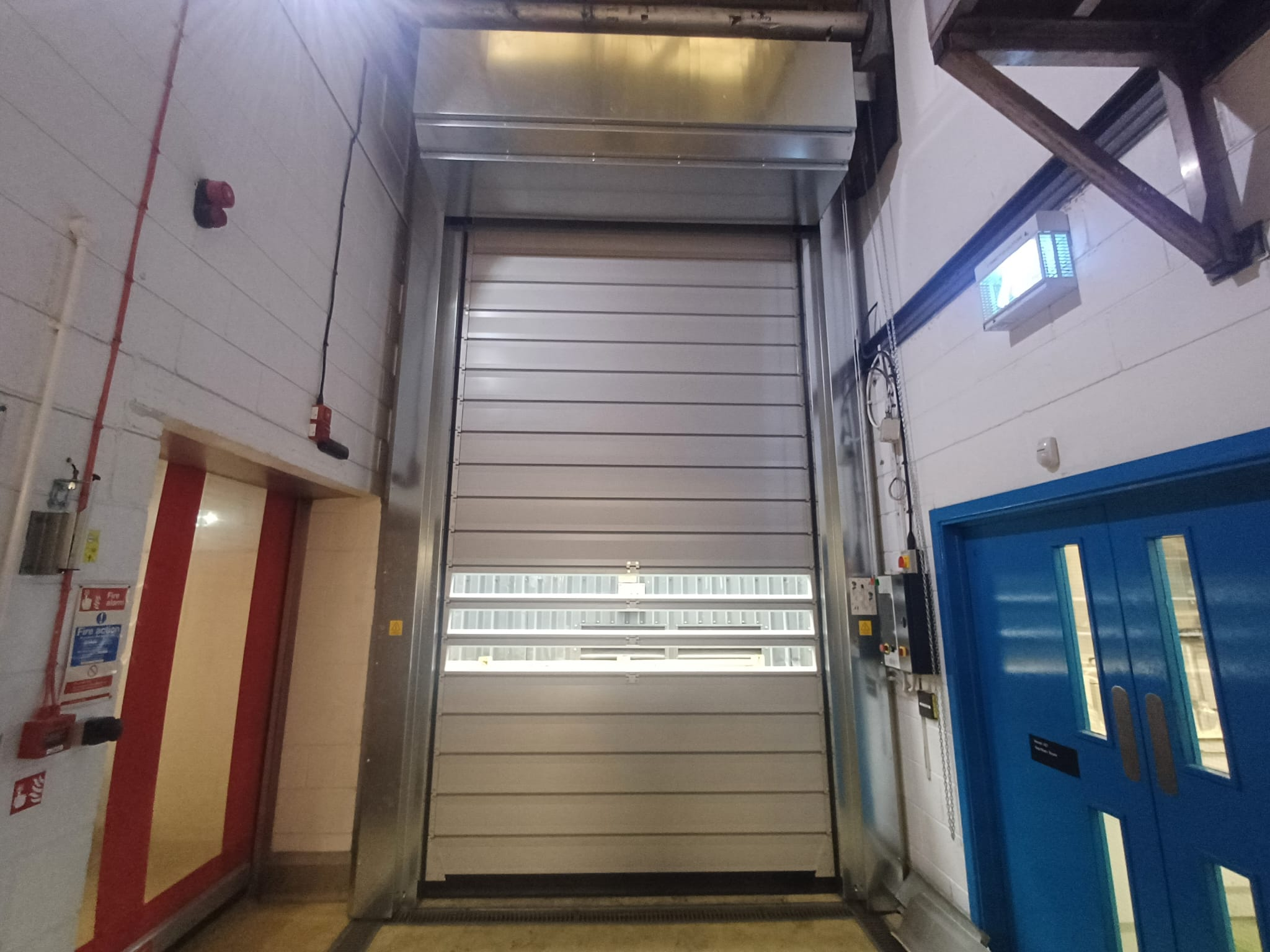 Insulated high speed door installed at a temperature-controlled opening