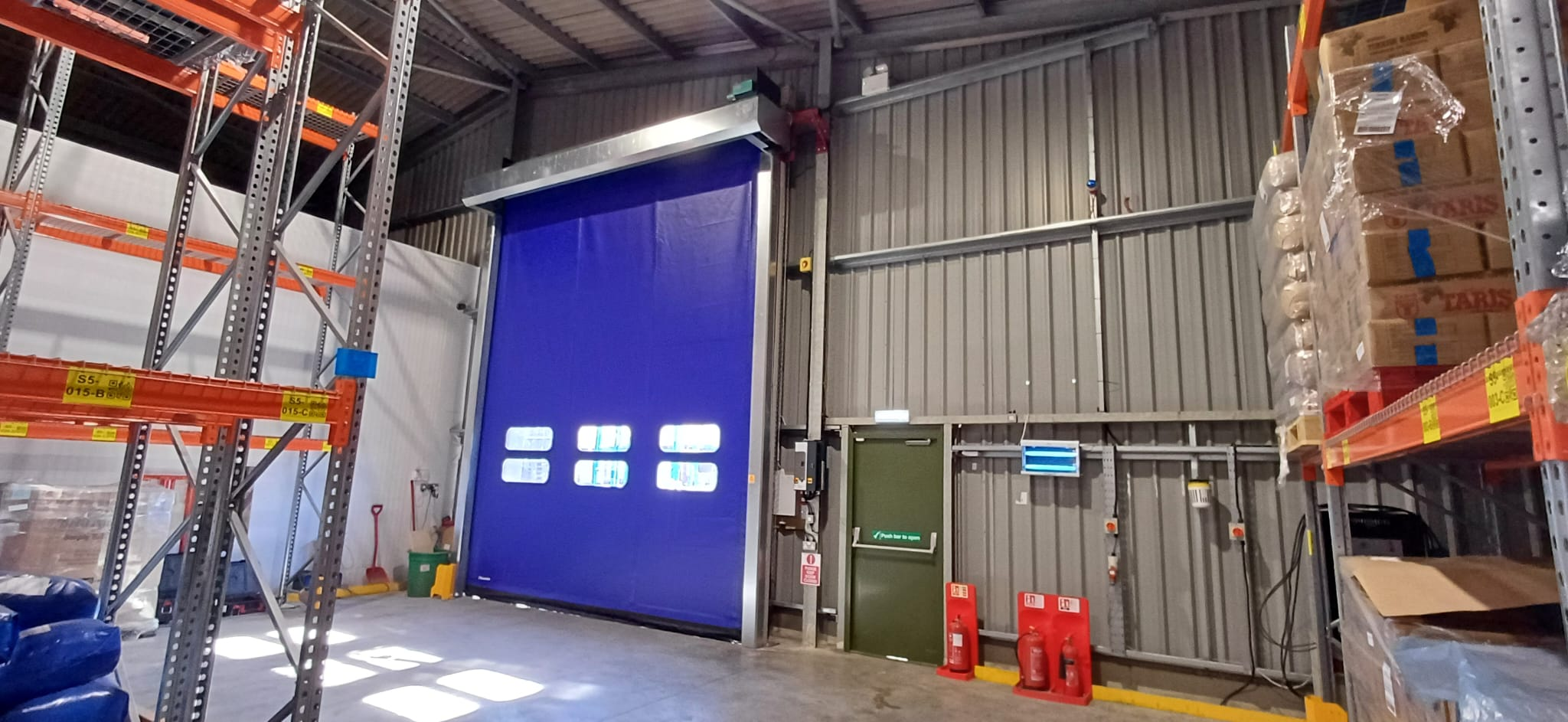 Blue self-repairing high speed PVC zip door in a warehouse