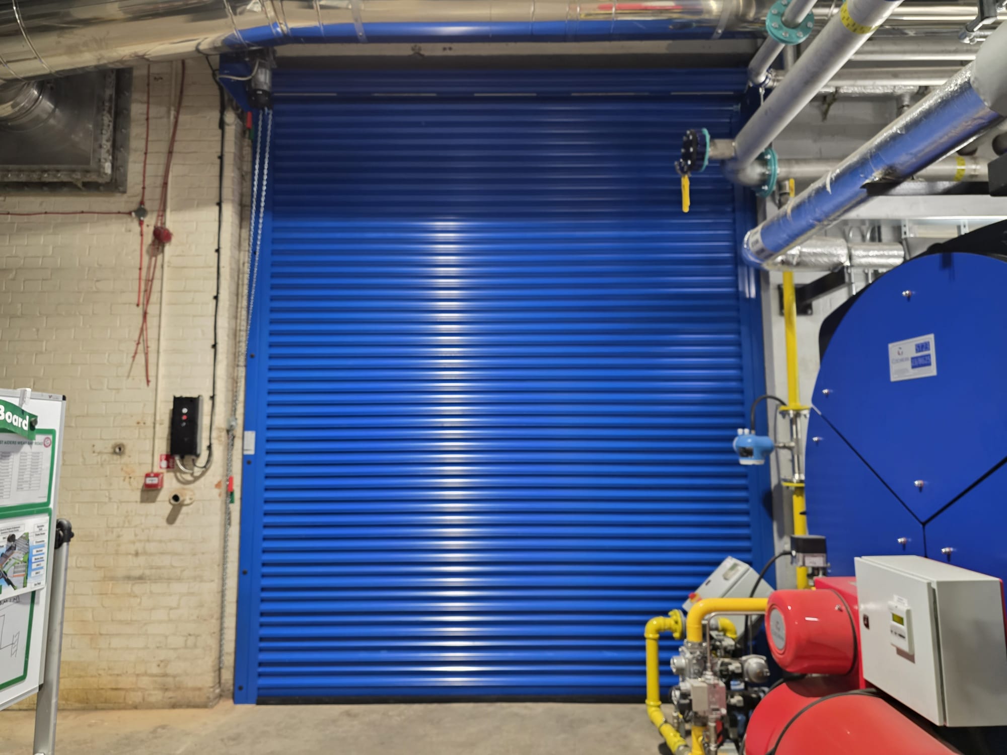 Blue roller shutter installed within a plant room